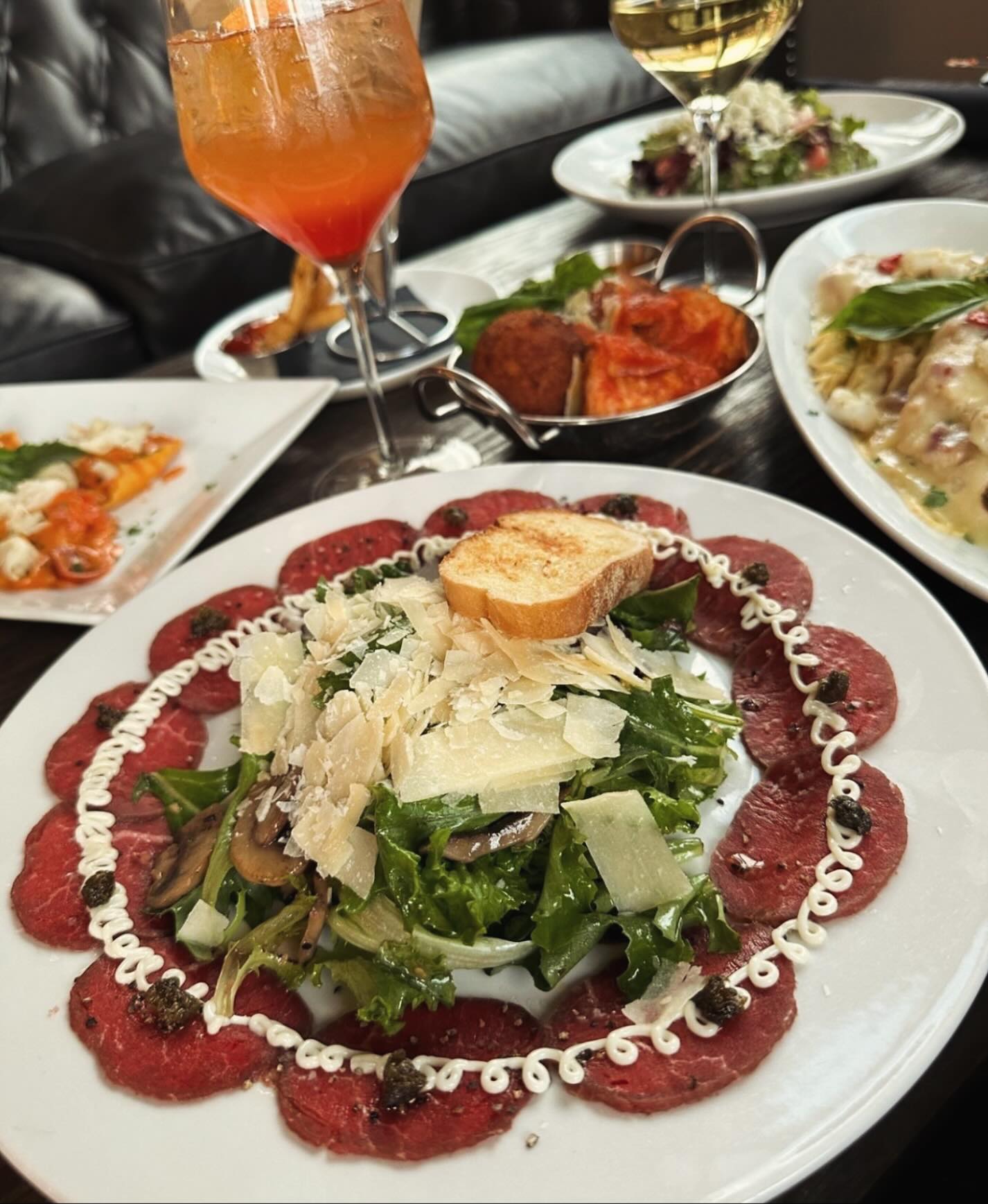 Thinly sliced beef carpaccio with arugula, mushrooms, and shaved parmesan
