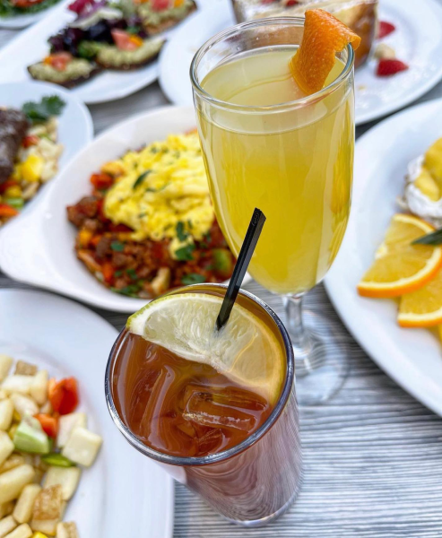 A collection of brunch dishes and cocktails on a table. 