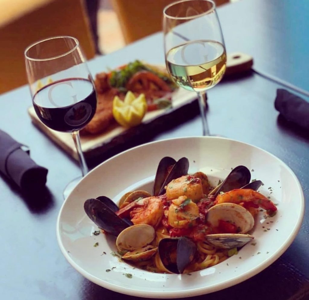 Seafood pasta with mussels, clams, shrimp, and scallops paired with red and white wine at Galliano Italian Restaurant