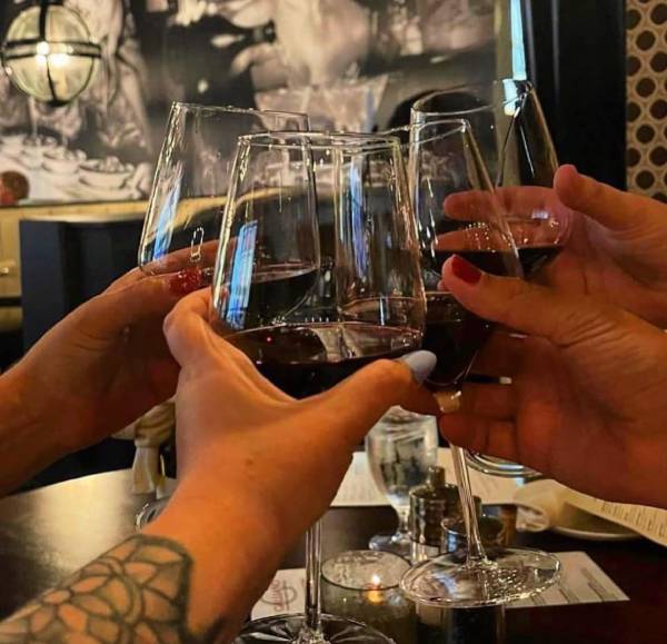 riends clinking glasses of red wine at Galliano Italian Restaurant