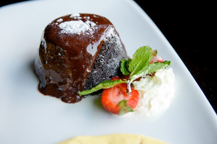 Decadent chocolate dessert with whipped cream and berry